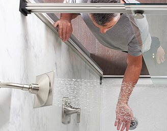 A man checking the water in a Kohler Shower